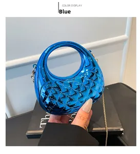 Close-up of a blue acrylic quilted crescent evening bag with a stylish gold chain strap
