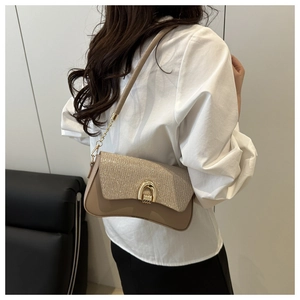 Detail of glitter sequins and horseshoe buckle on beige crossbody shoulder bag