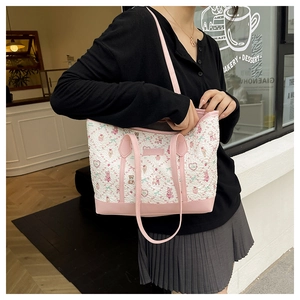 Detailed view of cute bear pattern tote bag with pink leather trim and handles