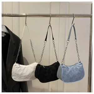 Collection of three floral textured baguette underarm bags in white, black and blue.