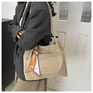 Detail of khaki lychee texture tote bag with woven strap and decorative floral silk scarf