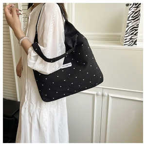 Vue détaillée du sac cabas floral noir avec motifs de fleurs blanches et étiquette Creative Cat