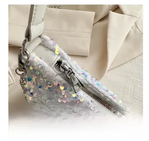 Macro shot of smooth silver zipper and iridescent sequins on a cream-colored bag