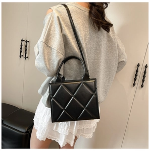 Détail du sac cabas matelassé noir en similicuir avec finitions métalliques élégantes