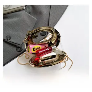 Detail view of G-shaped acrylic bag capacity with golden metal frame and chain