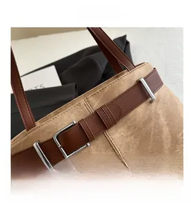 Macro detail of khaki suede shoulder bag with brown leather strap and silver buckle