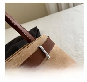 Detail shot of khaki canvas and brown leather stitching with silver rectangle buckle