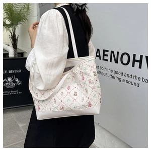 Detail of floral tote bag with cute bear patterns and pleated fabric texture on shoulder