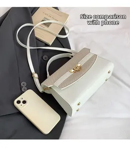 Mini borsa Kelly crema con patta intrecciata accanto a uno smartphone per confronto taglia