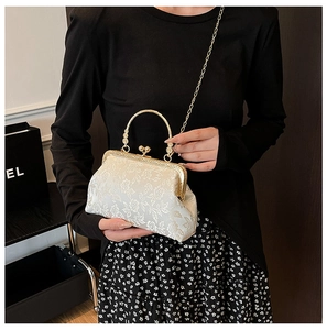Détail d'un sac à main vintage en jacquard floral crème avec fermoir doré et poignée