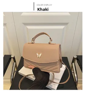Detail of khaki crossbody bag with V-shaped quilting and white butterfly buckle