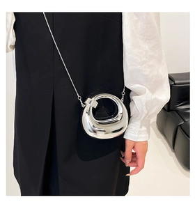Macro view of metallic silver crescent bag with mirror finish and slim chain strap