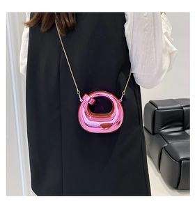Miniature pink metallic moon bag with stylish chain shown as an accessory on a model