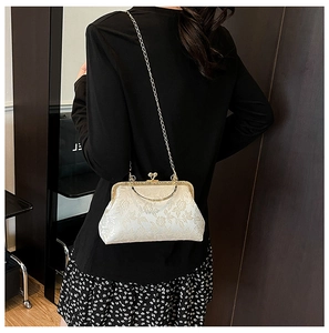 Détail du tissu jacquard floral blanc et du fermoir doré de ce sac à bandoulière