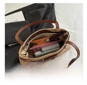 Top view of spacious khaki canvas tote with brown leather straps and interior zip pocket