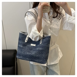 Détail du sac cabas en denim bleu foncé avec texture flocon de neige et étiquette en cuir