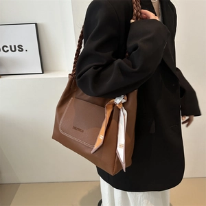 Brown large capacity leather tote bag with woven strap and decorative scarf accent