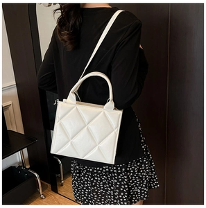 Détail du sac cabas blanc matelassé avec surpiqûres en losange et texture cuir
