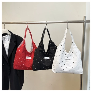 Trois sacs cabas en toile rouge noir et blanc avec motif à pois classiques et étiquette