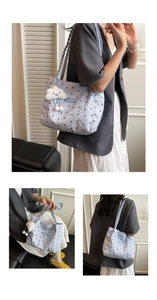 Close-up of light blue pleated tote bag with black bow print and cloud plush charm