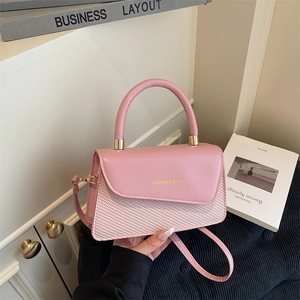 Sac bandoulière rose en cuir avec texture tressée et lettrage doré de mode chic