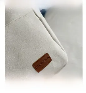 Detailed close-up of premium canvas fabric texture and precise stitching on the tote bag