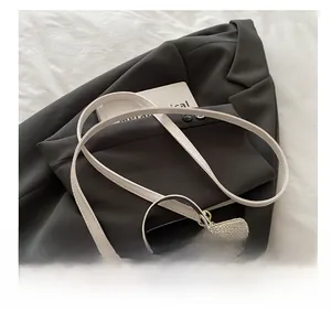 Detail of adjustable shoulder strap and gold-tone zippers on contrast stitch box bag