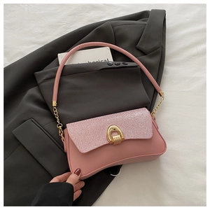 Close-up of pink shoulder bag featuring glitter texture and golden horseshoe buckle