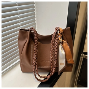 Détail du sac cabas marron à motif litchi avec bandoulière tressée et foulard en soie chic