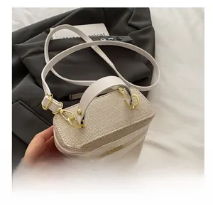 Detailed macro of beige woven canvas handbag with white leather trim and gold zippers