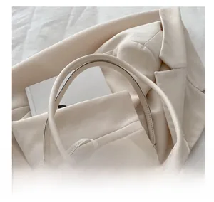 Close-up of cream beige handbag handle with elegant lace bow detail and smooth leather finish