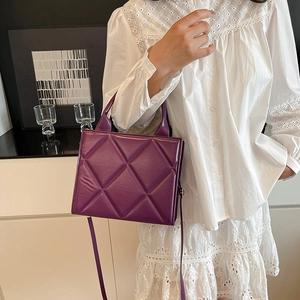 Sac fourre-tout matelassé violet avec poignée et bandoulière porté par un mannequin