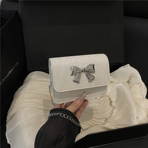 Minimalist white textured leather crossbody bag with silver bow accent and chain strap