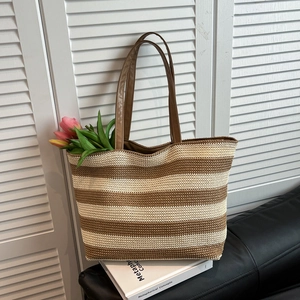 Large striped straw tote bag with brown leather handles for beach and summer travel