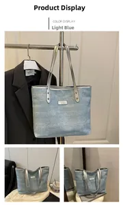 Detail of light blue denim tote bag with silver chain strap and fashion label tag