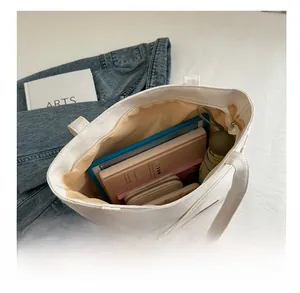 Spacious interior of white canvas tote bag showing tablet, notebook, and daily essentials