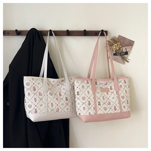 Detail of quilted tote bags with cute cartoon patterns hanging on wooden wall hooks