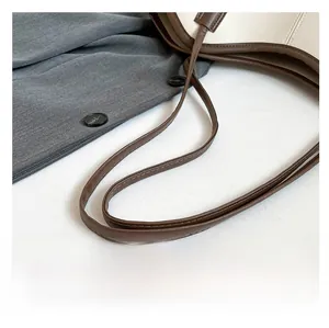 Detail of dark brown leather tote strap with precise double stitching and premium texture