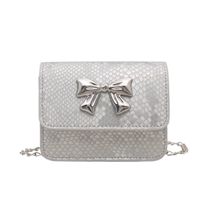 Silver snakeskin crossbody bag with a metal bow accent and chain strap on white background