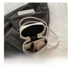 Detail of straw woven crossbody bag interior showing spacious storage for daily essentials