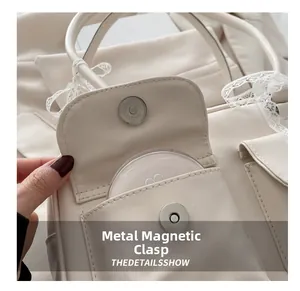 Detail shot of the cream shoulder bag showing the magnetic metal clasp and side pocket