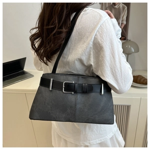 Detail of dark grey underarm bag featuring a black belt buckle and silver square hardware