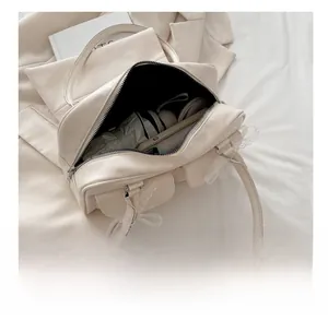 Internal capacity of the cream shoulder bag showing daily essentials and lace details