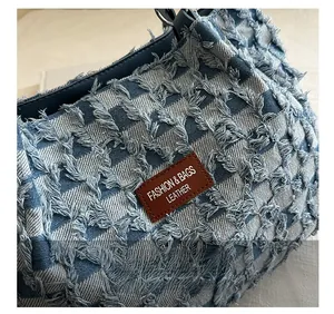 Detailed close-up of blue and white checkered denim fabric with frayed edges and leather patch