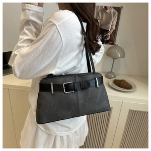 Detail of dark grey suede underarm bag with black leather strap and silver buckle