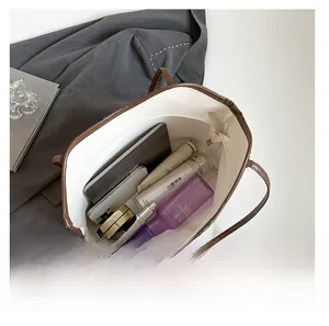 Top view of white tote bag interior showing large capacity for laptop and cosmetics