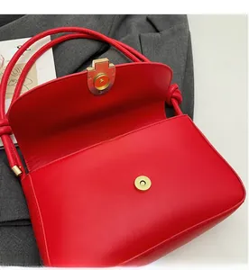 Detail of red leather bag showing the secure magnetic snap closure and texture