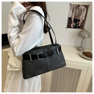 Close-up of matte charcoal shoulder bag featuring a silver buckle and belt strap detail