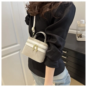 Detail view of woven top-handle crossbody bag with adjustable shoulder strap on model