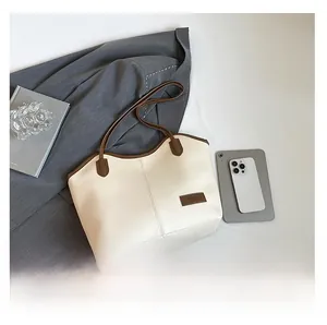 Close-up of cream white tote bag with contrast brown trim and premium leather texture
